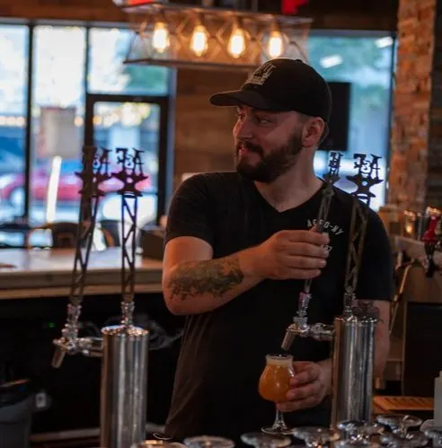 A bartender pours a craft beer at Anvil & Forge